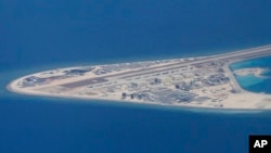 菲律宾空军一架运输机在南中国海南沙群岛的中国造的人造岛礁渚碧礁上空飞越时拍摄的照片,显示人造岛礁上的简易机场和建筑物。(2017年4月21日)