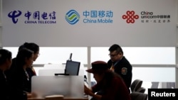 资料照:2018年11月5日在上海举行的中国国际进口博览会上显示的中国电信、中国移动和中国联通的标识。