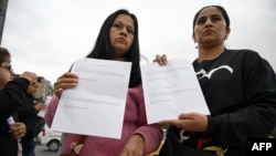 Women hold letters from the US embassy after their visa appointments was cancelled in Bogota on Jan. 27, 2025.