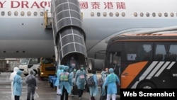 接载港人从武汉撤离的包机3月4日下午返抵香港国际机场。机上港人离开飞机后随即在身着保护衣的工作人员指示下登上专车前往隔离营。(香港政府新闻处)