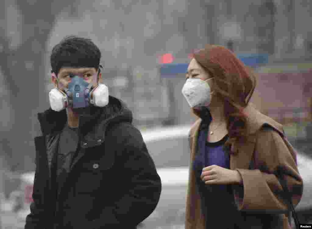 2015年12月8日,在北京首次发布空气污染红色警报后, 一位男子戴着奇特的口罩设备