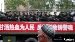 乌鲁木齐的街道上,维吾尔人开着卡车上的武警,卡车上的标语说“甘洒热血为人民”