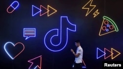 一名男子在应用程序TikTok标识前走过。(2019年10月18日)