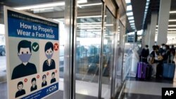 资料照片:芝加哥国际机场入境地区要求旅客佩戴口罩的告示(2020年7月2日)