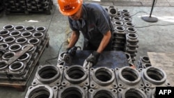 中国江苏省连云港,一名工人在工厂里加工传动部件。