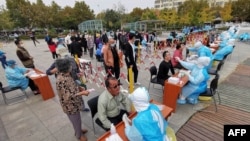 中国山东省青岛市的医护人员继续给市民做新冠病毒核酸检测。(2020年10月13日)