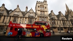 2020年10月6日英国冠状病毒病下,一辆观光巴士经过牛津大学大楼