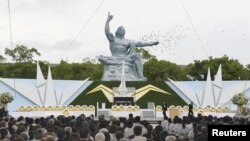 日本长崎的和平公园纪念原子弹轰炸72周年,鸽子在和平雕塑上空飞过(2017年8月9日)