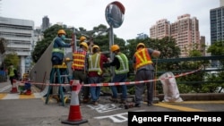 2022年1月29日,香港建筑工人用铁板覆盖住漆有六四标语的港大太古桥桥面。