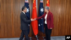 2024年3月20日星期三,中国外交部长王毅(左)在堪培拉议会大厦与澳大利亚外交部长黄英贤会面。
