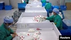 上海一家工厂的工人在生产线上赶制口罩。(2020年1月31日)