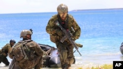 资料照:2017年5月13日,日本、法国、美国和英国在关岛海军基地举行联合军事演习,日本士兵使用橡皮筏作为两栖演习的一部分。(美联社图片)