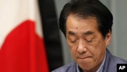 日本首相菅直人在记者会上,旁边是镶了黑边的日本国旗