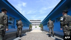 2018年4月26日,在韩国和朝鲜之间的非军事区板门店休战村的军事分界线前面,站着韩国士兵(前)和朝鲜士兵(后)。