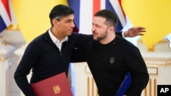 英国首相苏纳克与乌克兰总统泽连斯基在基辅签署文件后拥抱。(2024年1月12日)