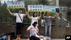 同性恋权利活动人士在北京一家法院外表演和抗议对同性恋实施的电击转化治疗。(2014年7月31日)