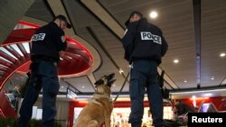 在巴黎戴高乐机场的一个候机厅,警察带着警犬站岗(2016年5月19日)