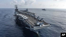 资料照:美国海军公布的照片显示里根号航空母舰与米利厄斯号导弹驱逐舰与日本海上自卫队一道在南中国海进行演习。(2018年8月31日)