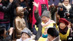 在二战期间曾被迫充当日军慰安妇的韩国妇女在日本驻首尔大使馆前的一座韩国前慰安妇的雕塑前集会,要求日本政府正式道歉与赔偿。(资料照片)