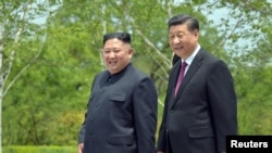 朝鲜中央通讯社2019年6月21日发布的这张照片中,中国国家主席习近平和朝鲜领导人金正恩在朝鲜平壤访问期间散步。