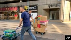 工人们在香港一家公司门前走过,其地址为中资的“中国创新投资”。(2019年11月23日)