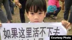 一名参加茂名抗议的儿童举着标语牌:如果这里活不下去,我们就去火星……