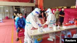 中国云南边境城市瑞丽民众在排队接受新冠病毒核酸检测。(2021年7月5日)