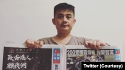 欧彪峰手持香港苹果日报表达支持港人民主诉求。(欧彪峰推特图片)