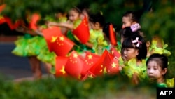 2013年10月13日,中国总理李克强访问越南时受到学童挥舞两国国旗的欢迎景象。