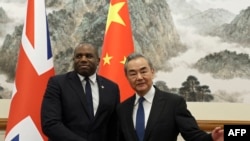 英国外交大臣戴维·拉米(左)和中国外交部长王毅于 2024 年 10 月 18 日在北京钓鱼台国宾馆会晤前握手。