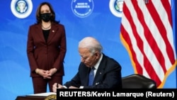 美国总统拜登签署一项行政命令后谈他的政府加强美国制造业的计划,副总统哈里斯站在一旁。(2021年1月25日)