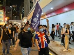 有游行人士身穿印上英国国旗的T恤,高举香港独立旗帜 (美国之音/汤惠芸)