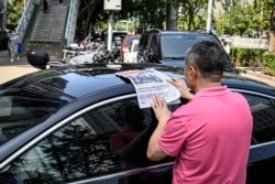 一名男子在北京街头阅读中共官媒环球时报对塔利班占领喀布尔的报道。(2021年8月17日)