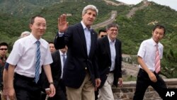 2014年7月8日,美国国务卿克里(中)美国财政部长雅各布•卢(右二)在参观长城时向记者招手