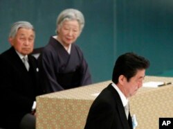 日本首相安倍晋三在日本武道馆举行的纪念战争亡灵活动中发表讲话后,走过天皇明仁和皇后美智子的身边。(2018年8月15日)