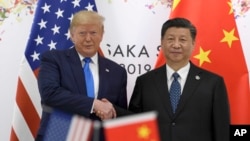 时任美国总统特朗普与中国国家主席习近平2019年6月在大阪召开的G20峰会上握手。(资料照片,2019年6月29日)