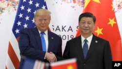 资料照:2019年6月29日,时任美国总统特朗普与中国国家主席习近平在大坂召开的G20峰会上握手。