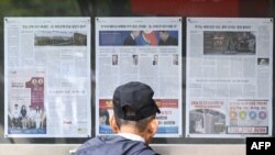 首尔街头一名男子阅读布告栏上的新闻报道,关于朝鲜向乌克兰前线部署数千名士兵的决定。(法新社:2024年10月21日)