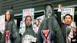 韩国的抗议者于2013年4月15日金日成的冥诞在首尔举行的反朝鲜的抗议活动中展示已故领导人金正日(右)以及金日成(左)的吊死人像。