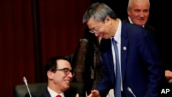 美国财政部长姆努钦与中国银行行长易纲星期六(2019年6月8日)在日本20国财长与央行行长会议期间握手。