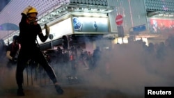 香港抗议者在警察施放的催泪弹烟雾中与港警对峙。(2019年10月20日)