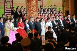 2018年6月19日,中国国家主席习近平和夫人彭丽媛,朝鲜领导人金正恩和夫人参加欢迎宴会,观赏文艺演出,和演员们合影。