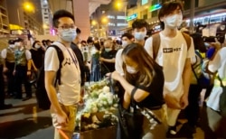 民主派油尖旺区议员林兆彬(左一)8月31日晚在太子地铁站出口摆放大型纸箱,协助市民献花纪念8-31警方涉嫌无差别袭击市民事件一周年 (美国之音/汤惠芸)