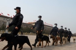 易富贤说,一个国家人口越老,政权越稳。图为中国两会期间警察在北京天安门广场巡逻。(2021年3月8日资料照)