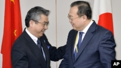 2015年3月19日在东京会晤前日本副外交部长杉山晉辅(左)和中国外交部部长助理刘建超握手