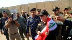 伊拉克总理哈德尔·阿巴迪(Haider al-Abadi)披着国旗,抵达摩苏尔市(2017年7月9日)