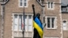 Американські ЗМІ публікують яскраві висловлювання військових, економістів та політичних оглядачів на тлі політичних суперечок у Конгресі США. На фото: прапор України довкола копії Статуї Свободи у Вашингтоні, США. AP Photo/Manuel Balce Ceneta