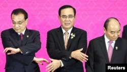 资料照片:中国国务院总理李克强和泰国总理巴育在泰国曼谷举行的第三次《区域全面经济伙伴关系》峰会上握手。(2019年11月4日)