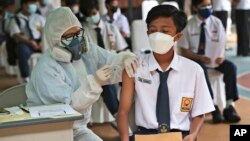 A medical worker gives a shot of the Sinovac COVID-19 vaccine to a student during a vaccination campaign for children between 12-17 years of age at a school in Tangerang, Indonesia, Wednesday, July 14, 2021. The world's fourth most populous county is struggling to acquire enough
