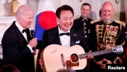 美国总统拜登在白宫赠送韩国总统尹锡悦一把吉他。(2023年4月26日)